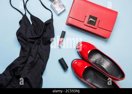 Elegante abito nero da donna e accessori rossi per feste. Disposizione piatta. Foto Stock