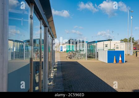 Si trova presso un centro Park and Ride, una struttura con servizio di autobus. Sono visibili i dettagli delle finestre in vetro e dei rack per cicli distanti insieme a TVCC. Foto Stock