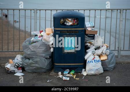 I rifiuti sono rimasti in un bidone traboccante a Porthcawl, Galles, Regno Unito, durante il periodo di blocco del coronavirus. Foto Stock