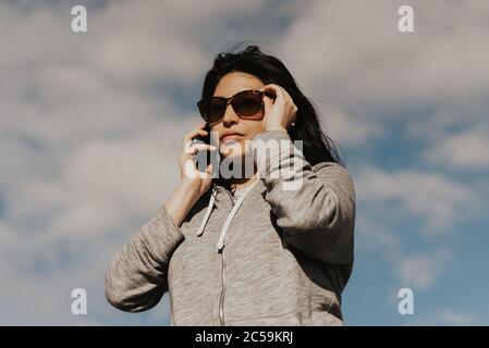 ritratto di bella donna ispanica che parla al telefono Foto Stock
