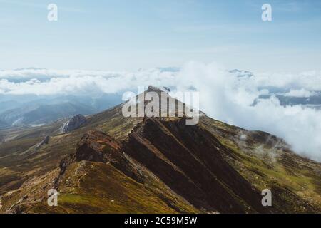 Cresta di montagna e nuvole che si avvolge dentro e fuori a Cantabria, Spagna del Nord. Foto Stock