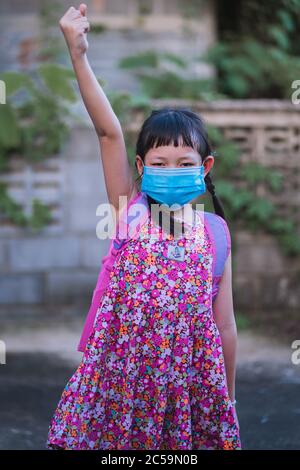 Asian studentessa ragazza che indossa maschera facciale con pronto per andare a scuola. Foto Stock