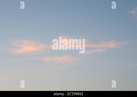 Le nuvole di Cirrus sono rosa dalla luce del sole che tramonta Foto Stock