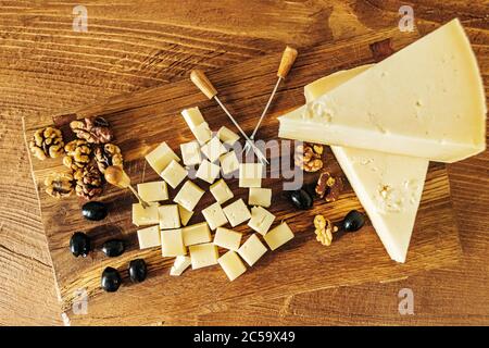 Composizione di cubetti di formaggio su un tavolo di legno guardaroba Foto Stock