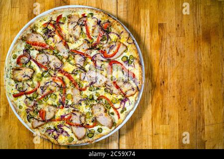 Pizza con pepe rosso su un tavolo di legno Foto Stock