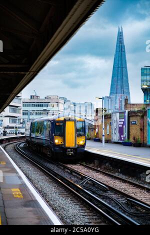 Treno che arriva alla stazione di Waterloo a Londra con vista sul grattacielo Shard sullo sfondo Foto Stock