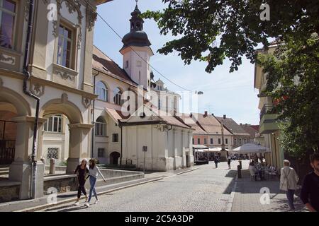 Strada lungo il lato del castello della città di Maribor nella città slovena. Terrazze con persone che bevono. Maribor, Slovenia, settembre 10 Foto Stock