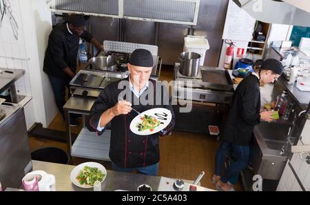 Il personale del ristorante con chef lavorano insieme in cucina Foto Stock