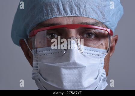 Ritratto di un medico che indossa i suoi , dispositivi di protezione individuale, DPI. Solo per la testa di primo piano. Foto Stock