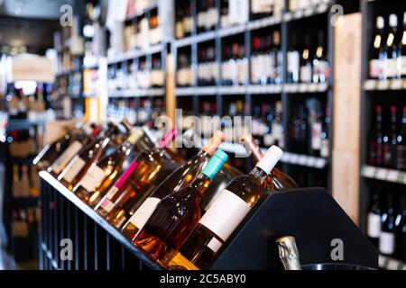 Rack con diverse bottiglie di vino in un moderno negozio di vini in attesa per i clienti Foto Stock