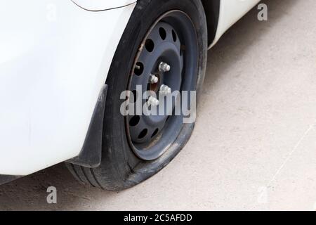 Ruota per auto con pneumatico sgonfio sulla strada. Incidente stradale, guasto automatico Foto Stock