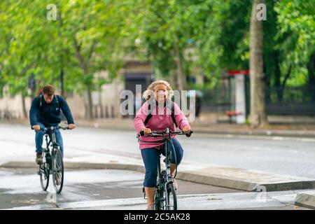 LONDRA, INGHILTERRA - 10 GIUGNO 2020: Sorriing amichevole vecchia donna in bicicletta pacifica in una giornata frizzante a Holborn, Londra durante la pandemia COVID-19 159 Foto Stock