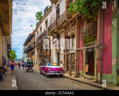 Havana, Cuba, 2019 luglio, scena urbana con un noleggio viola anni '50 Dodge auto parcheggiata in strada nella parte più antica della città Foto Stock