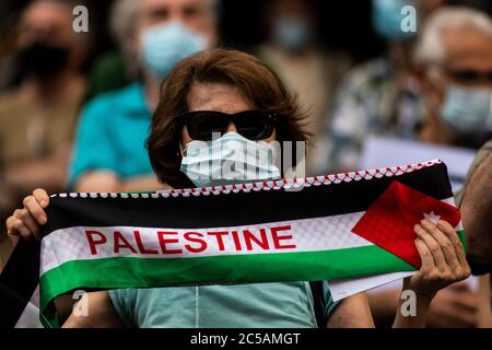 Madrid, Spagna. 1 luglio 2020. Una donna ha un vessillo della Palestina durante una protesta contro i piani di annessione della Cisgiordania davanti al Ministero degli Affari Esteri, dove si sono riuniti per dare sostegno al popolo palestinese. Credit: Marcos del Mazo/Alamy Live News Foto Stock