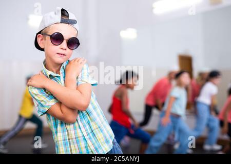 Ritratto di un ragazzo emozionale che fa movimenti hip hop durante la lezione di gruppo nel centro di danza Foto Stock