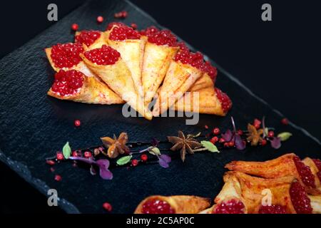 Pate di coniglio in corni croccanti decorato con spezie su un piatto di pietra nera Foto Stock