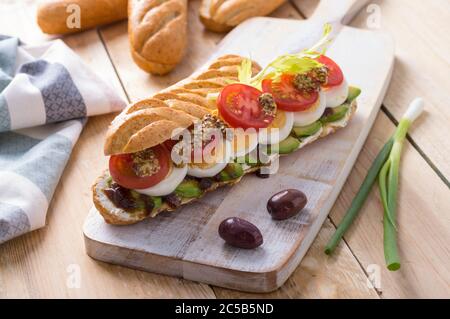 Panini freschi sottomarini con varietà di ripieni su sfondo di legno Foto Stock