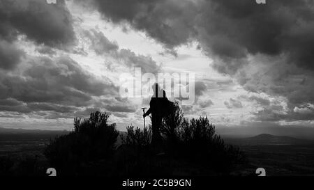 Un escursionista si trova sulla cima di Smith Rock in Oregon, quando una tempesta si lancia. Foto Stock