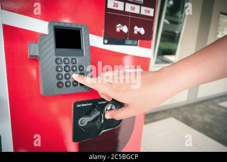 Distributore automatico per l'industria alimentare e delle bevande, donna premendo a mano il numero del pulsante sulla tastiera e il display di controllo per l'acquisto di prodotti alimentari Foto Stock