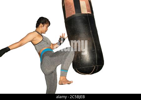 Bella ragazza asiatica con capelli lunghi pratica Muay Thai boxing da calciare a Boxing Sandbag al club fitness sport in sfondo bianco con clipping Path. Foto Stock