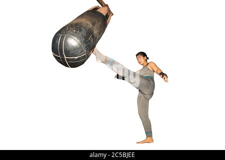 Bella ragazza asiatica con capelli lunghi pratica Muay Thai boxing da calciare a Boxing Sandbag al club fitness sport in sfondo bianco con clipping Path. Foto Stock