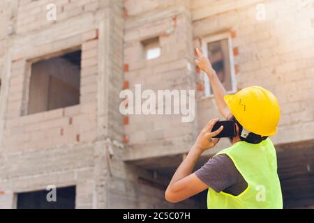 Ingegnere edile che punta con il dito verso l'edificio in costruzione Foto Stock