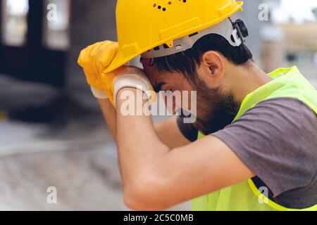 Un lavoratore di costruzione stanco gli ha asciugato la testa Foto Stock