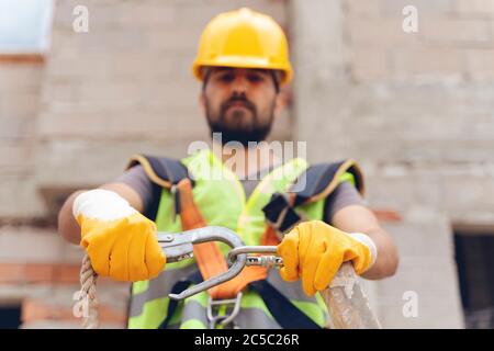 Lavori in altezza. Dispositivo anticaduta per lavoratori con ganci doppi per imbracatura per il corpo di sicurezza su fuoco selettivo. Costruzione come backgroun Foto Stock