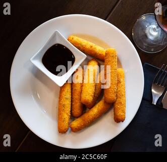 Deliziose barrette di mozzarella fritte in pangrattato servite con salsa Foto Stock