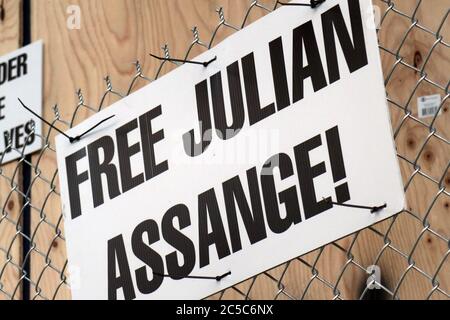 Un cartello apposto su una recinzione recita "Free Julian Assange". Foto Stock