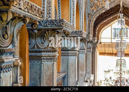 Un primo piano delle intricate incisioni sulle colonne di pietra all'interno dell'Abode di Nizam, presso il Palazzo Chowmahalla, Hyderabad, Telangana, India. Foto Stock