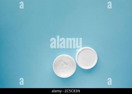 aprire il vaso per cosmetici vuoto su sfondo blu. vasetto per crema idratante. Vista dall'alto Foto Stock