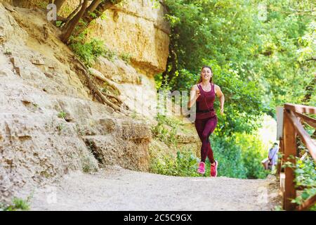 Una bella ragazza sportiva è impegnata nella mattina che corre all'aria aperta. Il concetto di uno stile di vita sano Foto Stock