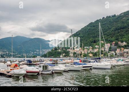 Vista sul Lago di Como. Porto del lago di Como con barca a vela e yacht al nuvoloso giorno d'estate. Foto Stock
