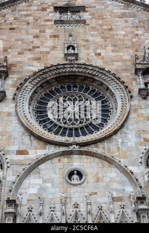 Parte della facciata esterna della Cattedrale di Santa Maria Assunta, meglio conosciuta come Cattedrale di Como. Rosone, tipico dell'architettura gotica. Foto Stock