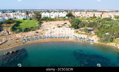 Veduta aerea dall'alto della spiaggia di Sirena a Protaras, Paralimni, Famagosta, Cipro. La famosa attrazione turistica della baia di Sirina con lettini, sabbia dorata, Foto Stock