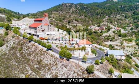 Vista aerea di Agios Arsenios chiesa, Kyperounda village, Limassol, Cipro. Punto di riferimento tradizionale cristiana ortodossa greca, ceramica tetto di tegole, pietra b Foto Stock