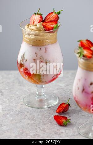 Dessert estivo freddo. Ciotole di gelatina stratificata servite sul tavolo su sfondo chiaro. Cocktail colorato e festoso con gelatina di dolci in vetro Foto Stock