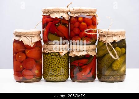 deliziosi sottaceti fatti in casa in vasi isolati su grigio Foto Stock