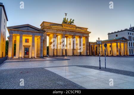 La famosa porta di Brandeburgo illuminata a Berlino al tramonto con nessuna gente