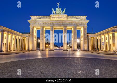 La famosa porta di Brandeburgo illuminata a Berlino all'alba senza persone