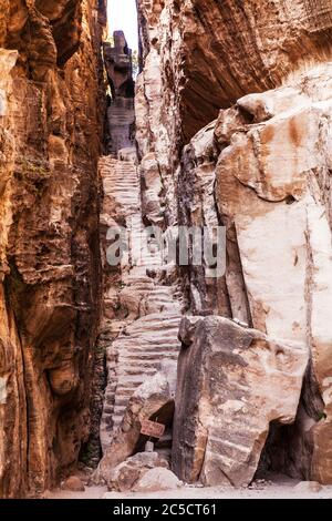 Passi tagliati attraverso uno stretto spazio nel canyon di Siq al-Barid o piccola Petra in Giordania Foto Stock