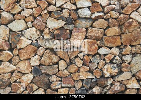 Frammento di un muro da una pietra scheggiata. Texture e sfondo per il tuo design Foto Stock