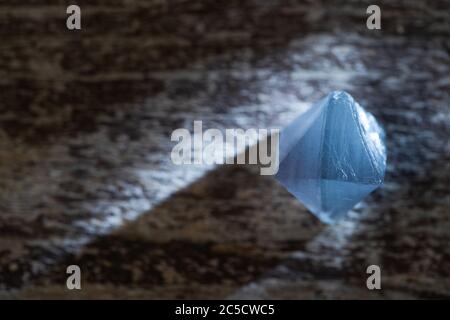 Primo piano vista del cristallo magico blu su superficie di legno con luce Foto Stock