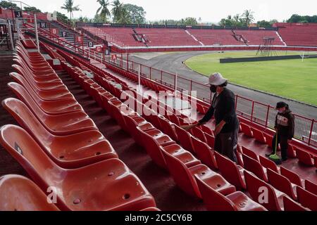 Gianyar, Bali, Indonesia. 2 luglio 2020. Le lavoratrici pulisce le panchine dello spettatore come manutenzione quotidiana. Indonesia Football Association (PSSI) preparerà sei stadi per la Coppa del mondo FIFA U-20 che sarà ospitata dall'Indonesia su 2021 compreso lo stadio di Bali; i WAYAN DIPTA, per conformarsi alla standardizzazione. Credit: Dicky Bisinglasi/ZUMA Wire/Alamy Live News Foto Stock