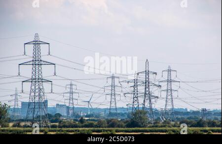 Una fila di piloni di elettricità si dipanano attraverso la campagna nel Regno Unito. Foto Stock