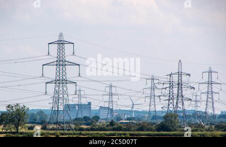 Una fila di piloni di elettricità si dipanano attraverso la campagna nel Regno Unito. Foto Stock