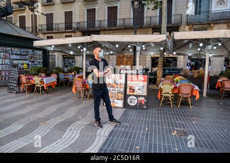 Barcellona, Spagna. 30 giugno 2020. Il cameriere che indossa una maschera facciale è visto in attesa per i clienti in uno dei ristoranti sempre occupati Las Ramblas a Barcellona.Barcellona attende l'arrivo dei turisti, tuttavia nonostante la riapertura dei confini, Il centro della città, in particolare il settore dell'intrattenimento, come i bar e i ristoranti, mostrano ancora segni della crisi del Covid-19. Credit: SOPA Images Limited/Alamy Live News Foto Stock