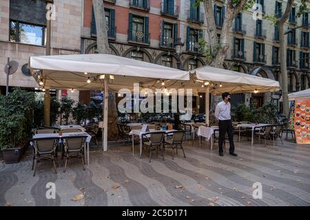 Barcellona, Spagna. 30 giugno 2020. Il cameriere che indossa una maschera facciale è visto in attesa per i clienti in uno dei ristoranti sempre occupati Las Ramblas a Barcellona.Barcellona attende l'arrivo dei turisti, tuttavia nonostante la riapertura dei confini, Il centro della città, in particolare il settore dell'intrattenimento, come i bar e i ristoranti, mostrano ancora segni della crisi del Covid-19. Credit: SOPA Images Limited/Alamy Live News Foto Stock