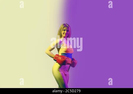 Ragazza sportiva facendo esercizi di boxe in guanti rossi. Forza e motivazione Foto Stock